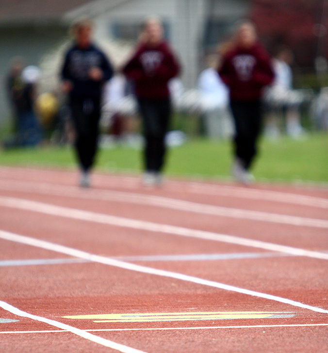 trainer-coaching-elderly Female runners running on the track.
