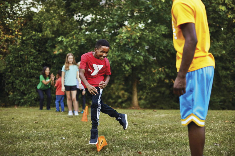 Kid dodging soccer cones during day camp